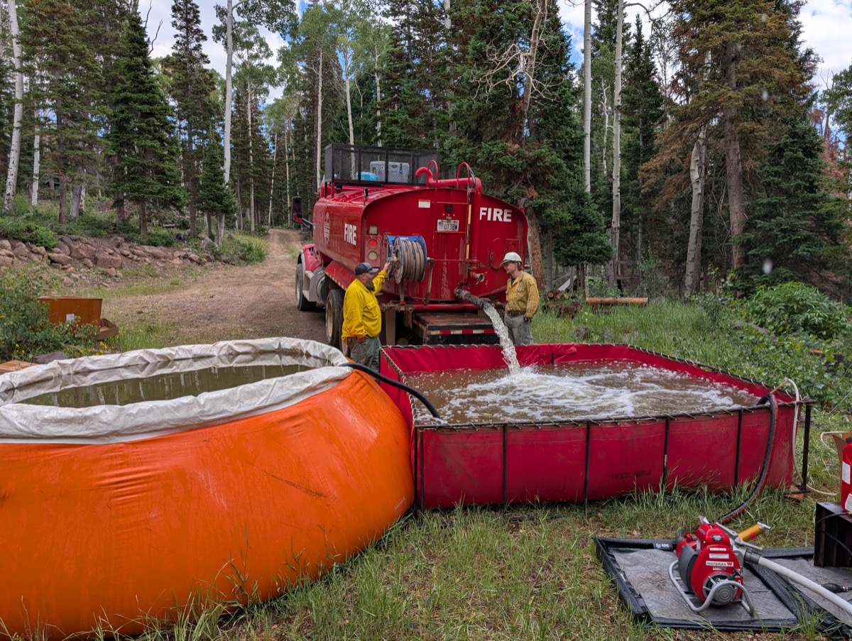 Water tender filling a portable tank on the fireline